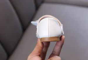 Close-up macro detail of the heel and fine stitching on white girls' princess dress shoes
