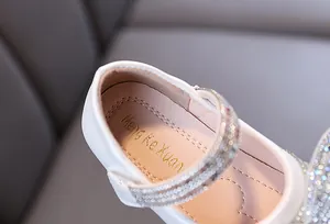 Detailed view of white girls princess flat shoe featuring sparkly rhinestone straps and soft insole