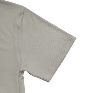 Detalle de la textura de tela acanalada en la manga corta de una camiseta gris de verano.