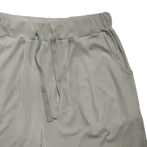 Detalle de pantalón casual gris de verano para hombre con cordón y cintura elástica.