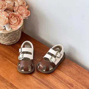 Detalle de sandalias bicolor marrones y blancas para niños con suelas blandas de verano