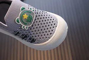 Detail view of the breathable mesh upper and star patch on toddler walking shoes