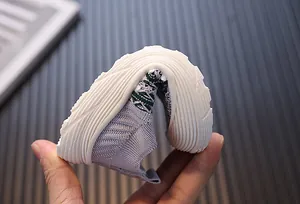 Detailed close-up showing the flexible soft sole of grey toddler fly-knit walking shoes
