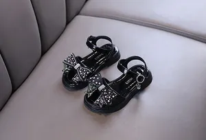 Vista detallada de las sandalias negras de princesa con lazos de diamantes de imitación