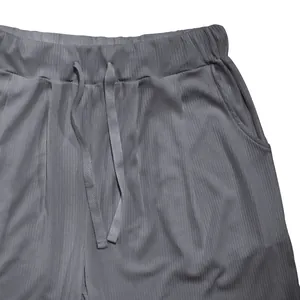 Detalle de pantalones cortos de canalé grises para hombre con cintura elástica y cordón