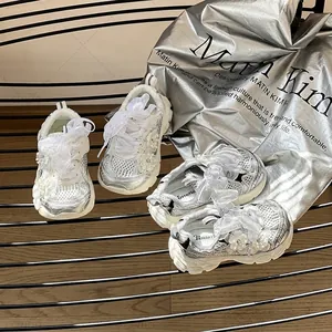 Zapatillas plateadas para niñas con detalles florales y cordones de cinta para bebés.