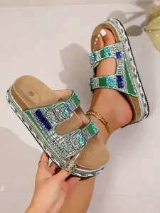 Detailed view of sparkling green and silver rhinestone platform sandals with cork sole