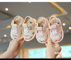 Primer plano de lindas sandalias para bebé con tema de conejo en colores rosa y crema