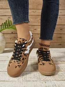 Nahaufnahme von Retro-GAT-Sneakern mit Leopardenmuster und Denim-Jeans