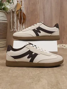 Detailansicht der cremeweißen Retro-Sneaker mit braunen Akzenten und Gummisohle.