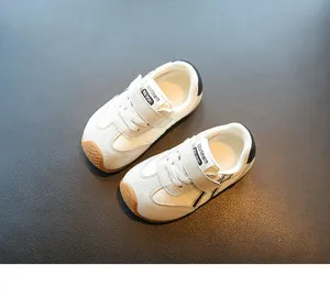 Close-up detail of white breathable toddler sneakers with velcro straps and brown toes