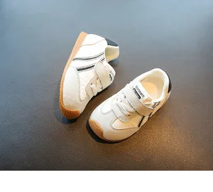 Detailed macro view of white breathable toddler sneakers with black stripes and velcro