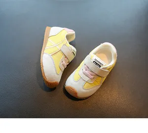Close-up of yellow and grey toddler sneakers with pink laces and breathable mesh