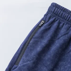 Close-up detail of navy tie-dye sports shorts with elastic waist and zipper pocket