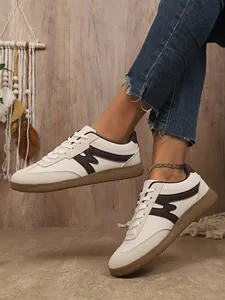 Seitenansicht der Damen Vintage-Sportschuhe mit braunen Details und Gummisohle.