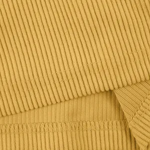 Primo piano della trama del tessuto in velluto a coste giallo senape e cuciture orlo.