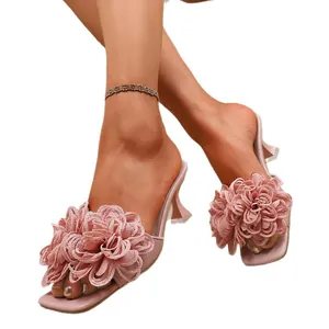 Eleganti sandali sabot rosa con tacco alto, grandi fiori in tessuto 3D e punta quadrata.