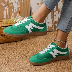 Trendige grüne Retro-Freizeitschuhe für Damen mit weißem Muster und robuster Gummisohle.