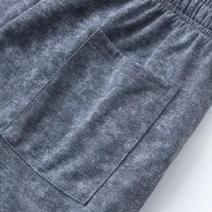 Macro view of the pocket detail and tie-dye fabric texture on men's gray sports shorts.