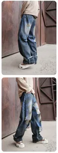 Vue détaillée d'un jean bleu délavé large avec détails usés style streetwear