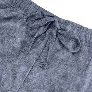 Close-up of tie-dye French terry shorts showing elastic waistband and drawstring detail.
