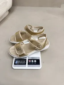 Vue détaillée d'une sandale de sport dorée sur une balance numérique indiquant un poids de 235 grammes