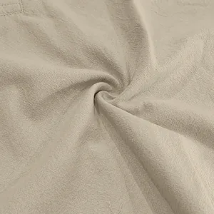 Macro detail of the breathable beige linen-blend fabric texture showing material quality.