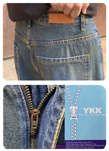 Vue détaillée de la fermeture éclair YKK et du patch en cuir sur un jean en denim bleu lavé
