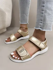 Gros plan détaillé de sandales sportives dorées avec brides velcro réglables