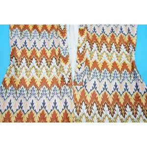Close-up of V-neck romper featuring colorful wave patterns and yellow buttons.