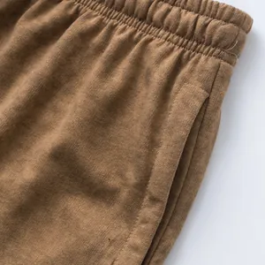 Detailed close-up of brown terry cotton men's casual shorts showing waistband and pocket