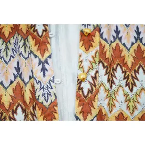Close-up of yellow pearl buttons and chevron wave pattern on a women's fashion romper detail.