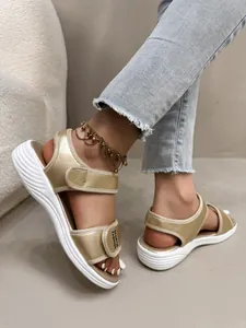 Vue rapprochée de sandales de sport à plateforme dorées pour femmes avec brides velcro