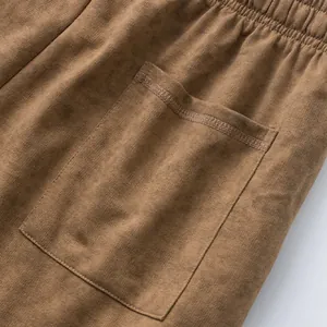 Close-up detail showing the pocket construction and washed tie-dye texture of brown shorts