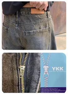 Gros plan sur la fermeture éclair YKK de haute qualité et les poches sur un denim gris.
