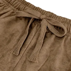 Detailed view of elastic waistband and flat woven drawstring on brown casual shorts