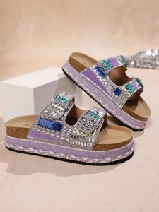 Close-up of luxurious purple rhinestone platform sandals featuring double belt buckles