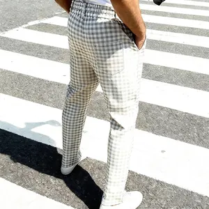 Detail van een lichtgrijze geruite heren slim fit casual katoenen broek op straatbeeld