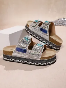 Detailed close-up view of rhinestone platform sandals with double buckles and cork sole