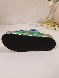 Detailed view of the grooved black outsole and cork platform of the rhinestone beach slides