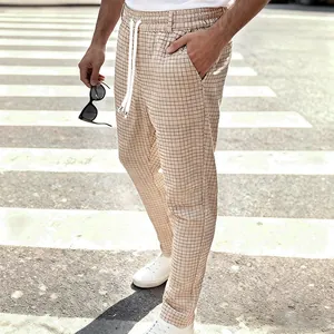 Detailopname van een beige geruite heren vrijetijdsbroek met een wit trekkoord