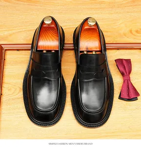 Gedetailleerd zicht op zwarte leren penny loafers met houten schoenspanners.