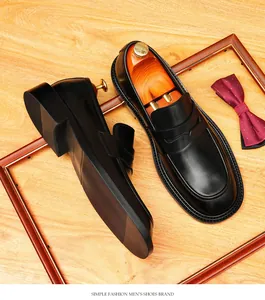 Premium zwarte leren penny loafers voor heren op een rustieke houten achtergrond
