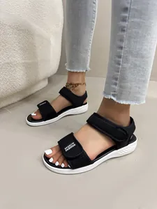 Gros plan de sandales de sport en maille noire pour femmes avec semelles blanches et scratchs.