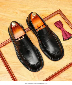 Gedetailleerd bovenaanzicht van zwarte leren penny loafers met houten schoenspanners