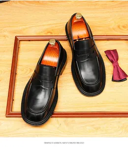 Gedetailleerd bovenaanzicht van zwarte leren loafers met houten schoenspanners en een das