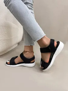 Détail de ces sandales de sport en maille noire avec velcro et semelles compensées blanches.