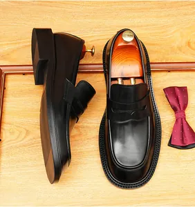 Gedetailleerd bovenaanzicht van klassieke zwarte lederen penny loafers in Britse zakelijke stijl