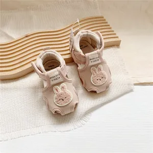 Detail showing pink baby walking sandals with cute rabbit embroidery and Velcro strap.