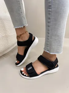 Gros plan de sandales à plateforme en maille noire pour femmes avec brides velcro.